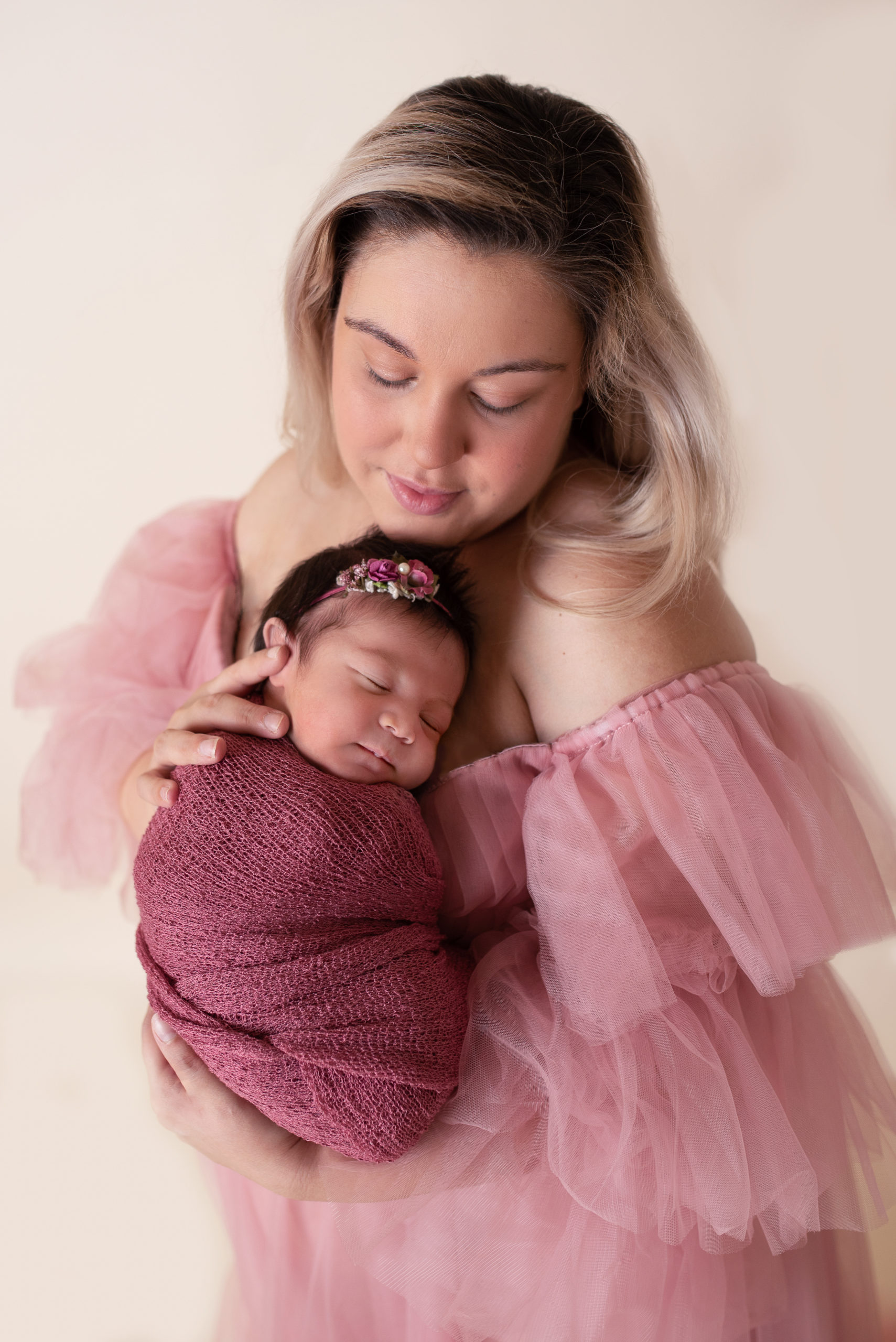 New mom holding baby girl dressed in pink Houston Birthing Centers