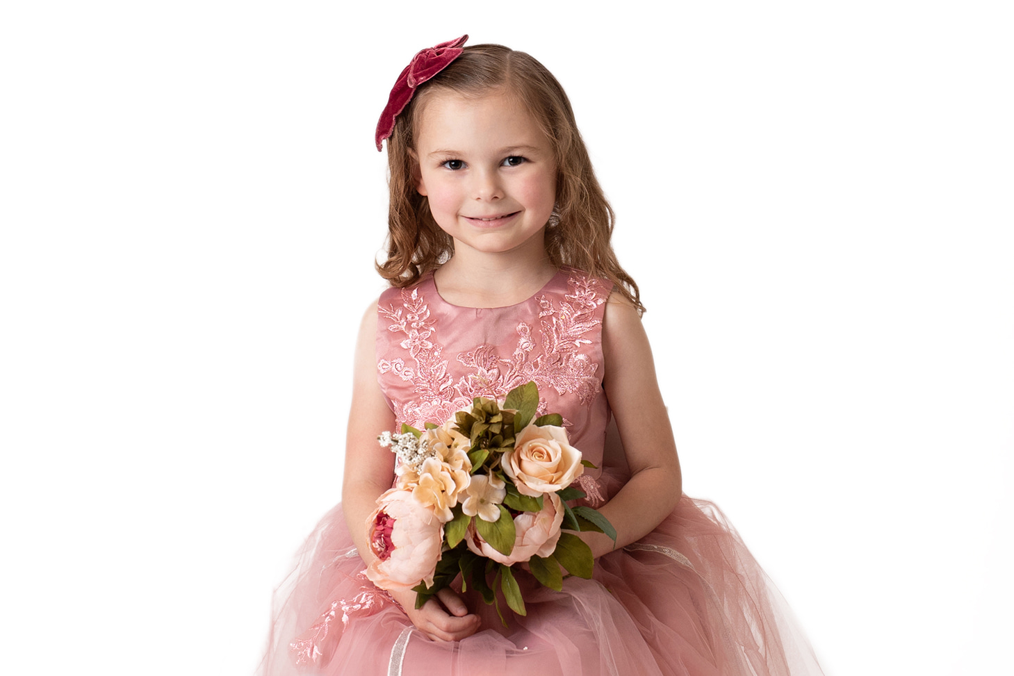 Little girl in a pink dress holding flowers