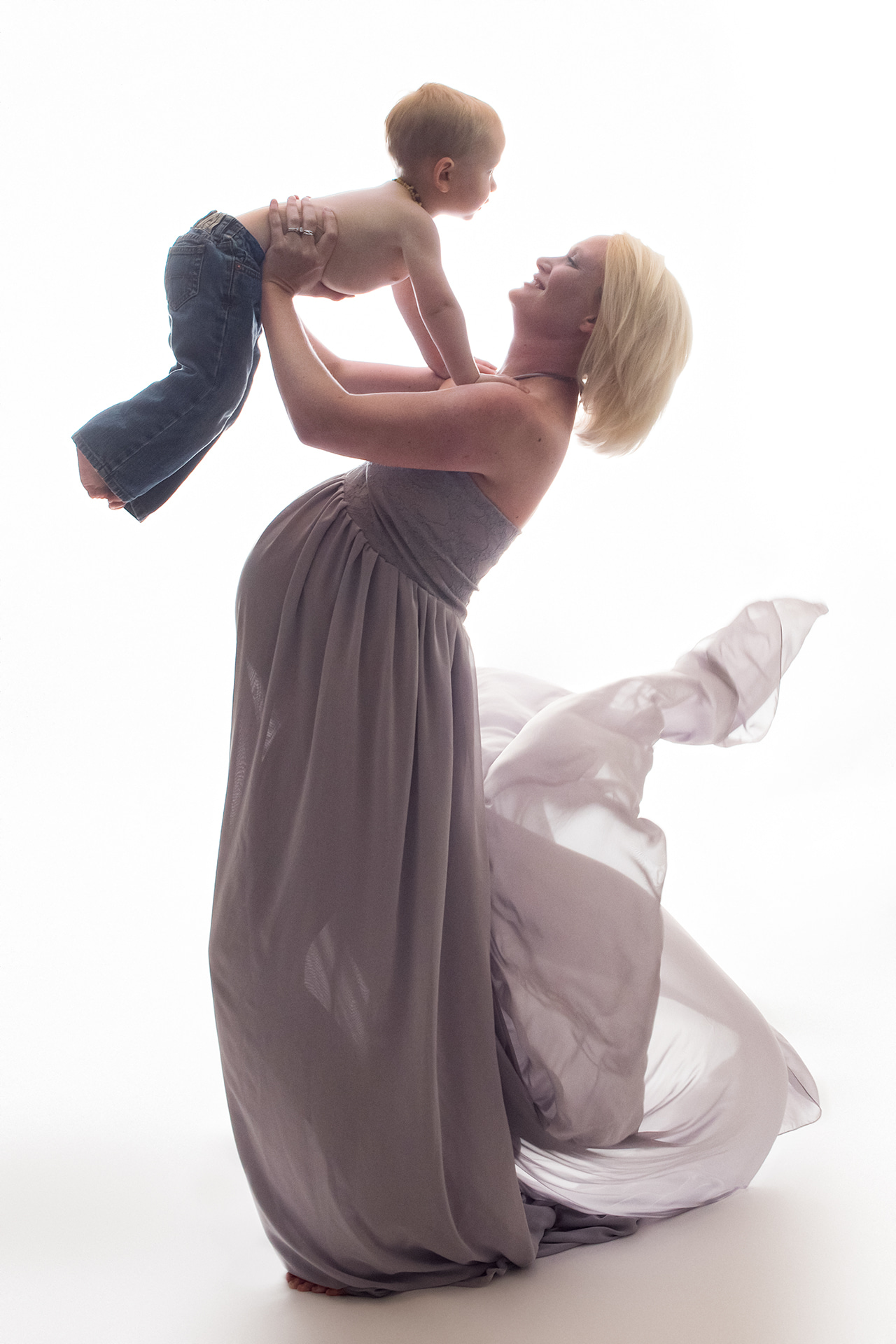 mom holding boy in the air with flowing dress Houston Prenatal Yoga