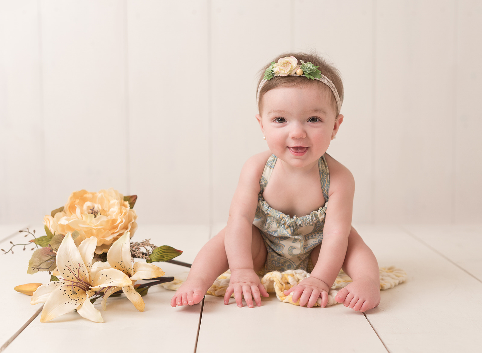 little girl in neutral clothes and headband playing on the floor baby clothes houston