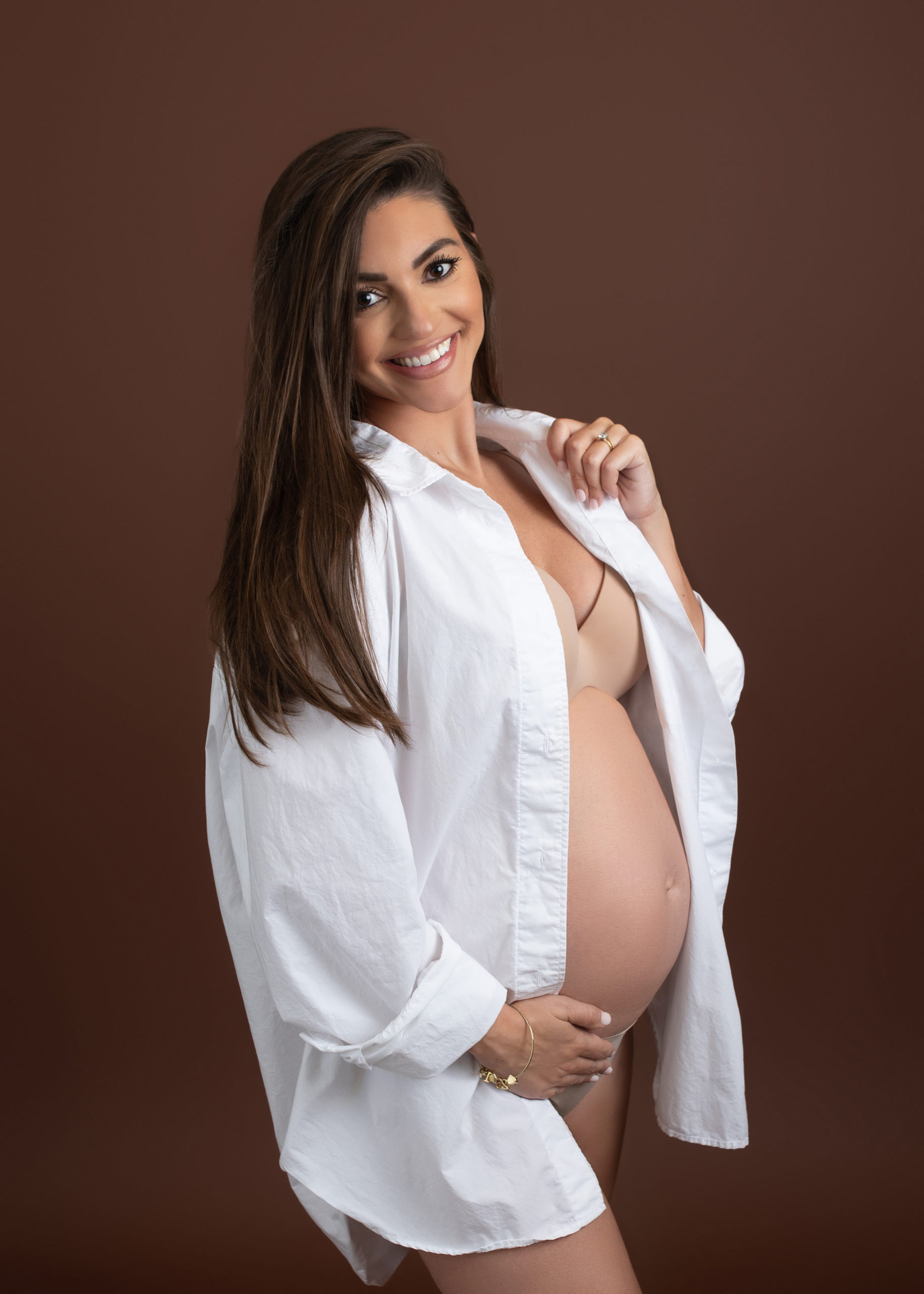 mom to be in opened white button down shirt holding her bump Galveston Birth Center