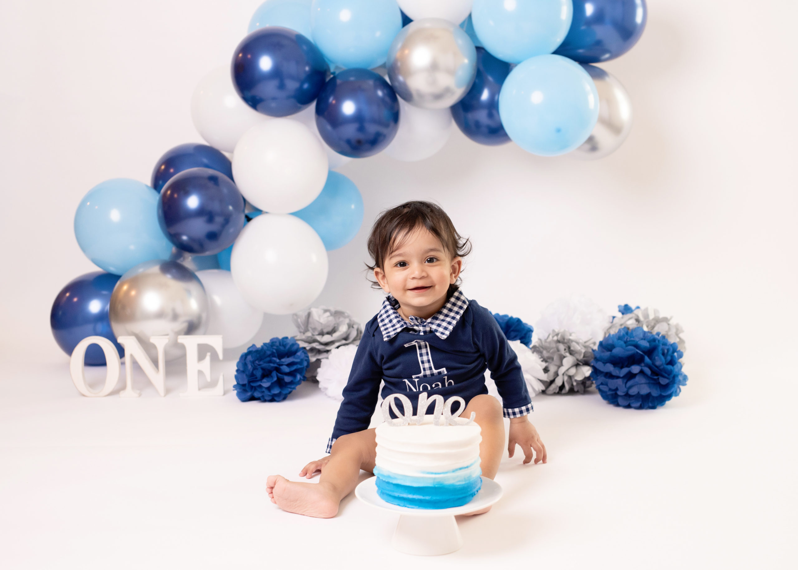little boy in blue outfit celebrating his first birthday The growing place webster tx