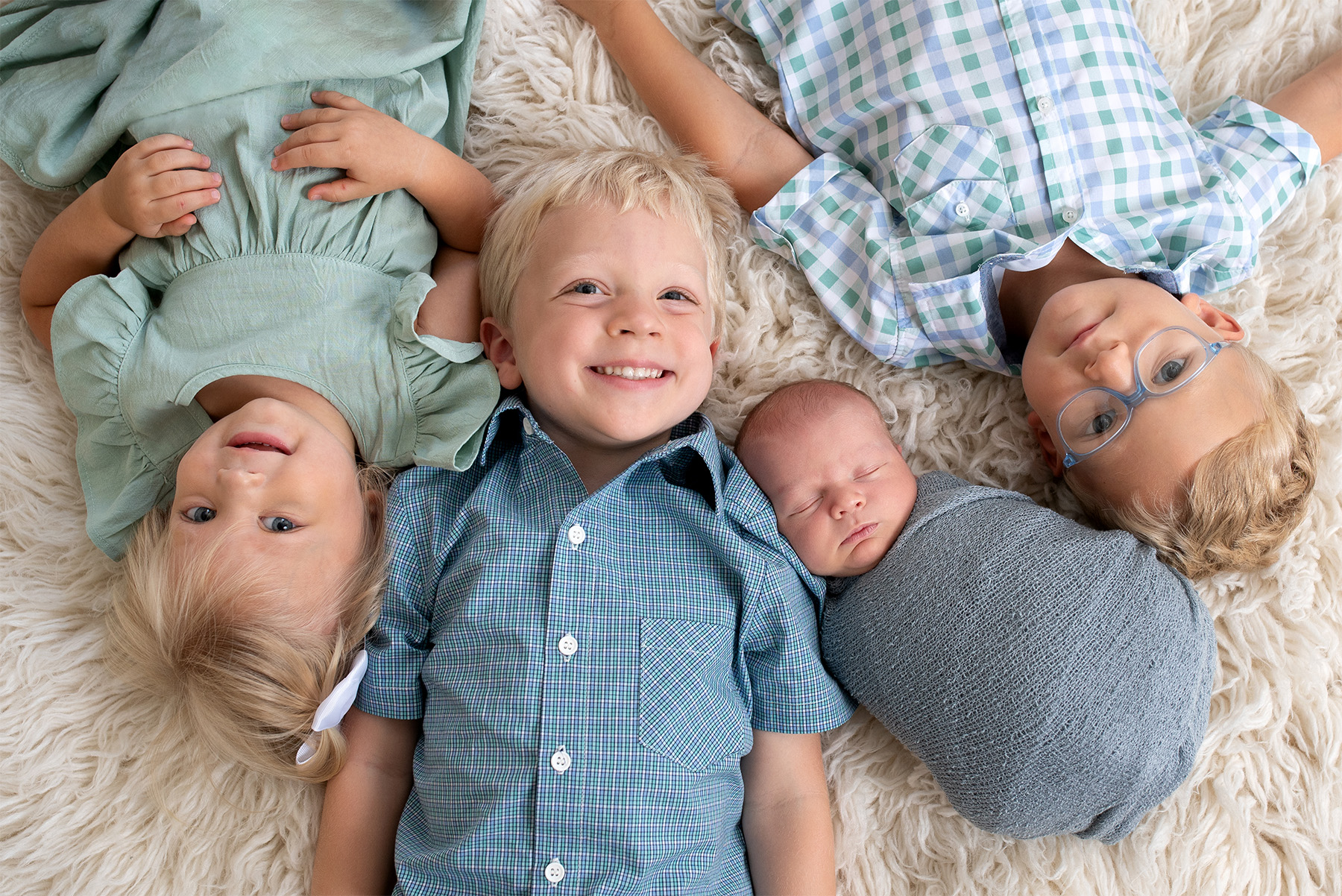 5 siblings in blue laying on the floor