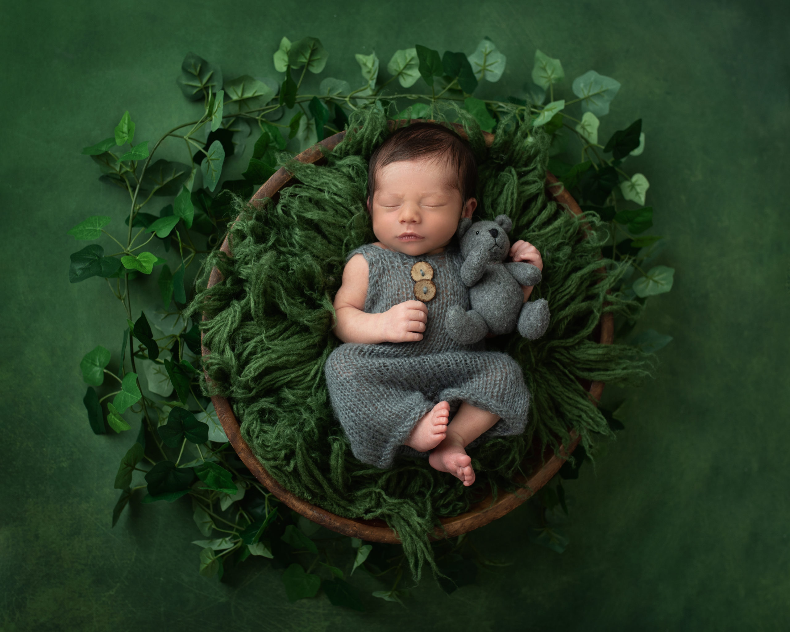 newborn baby laying in a bowl with green leaves Rockabye Baby Rentals